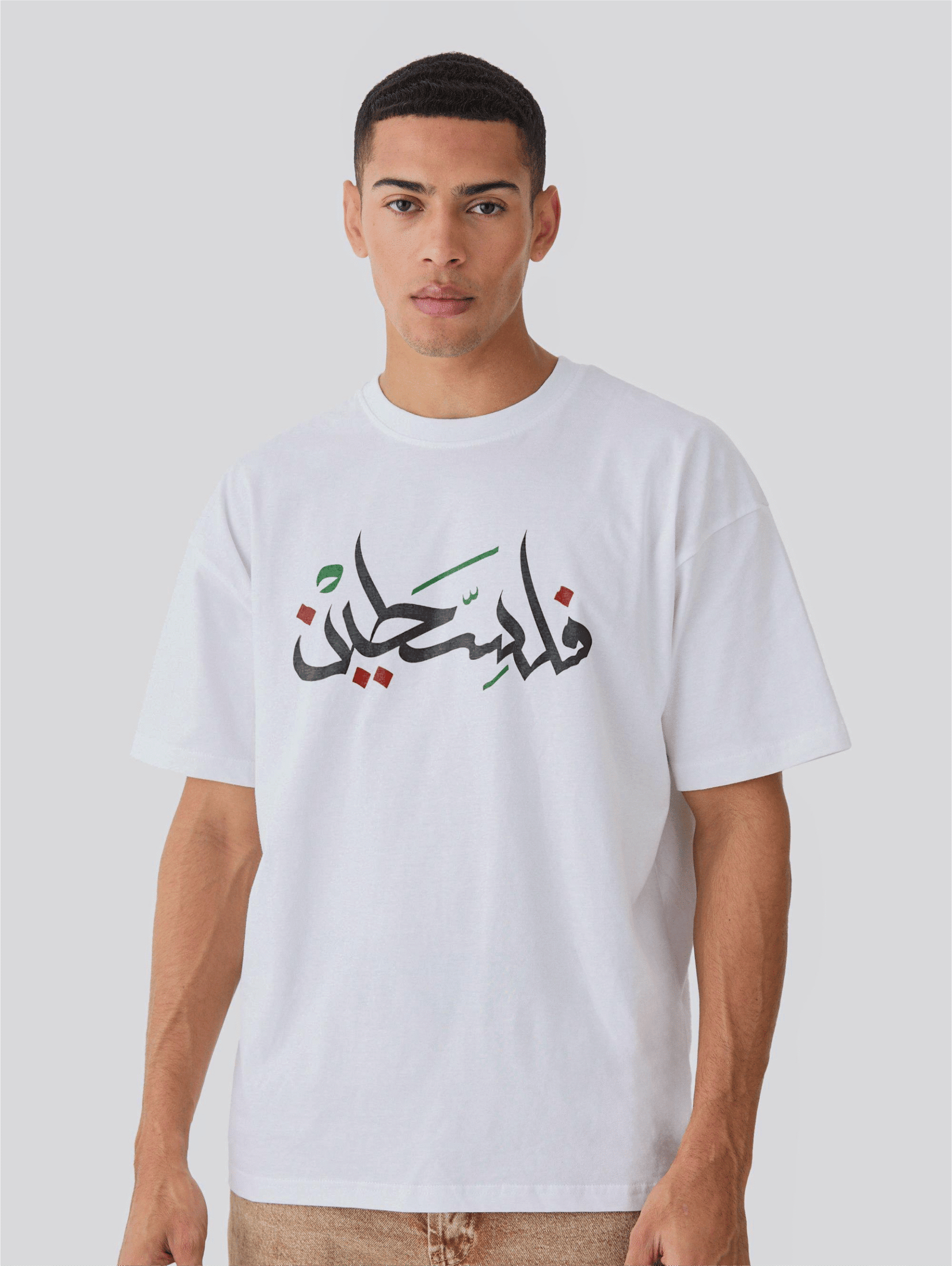 Man wearing oversized white Palestine T-shirt with Arabic فلسطين text and Palestinian flag design – only at Zaroodi India