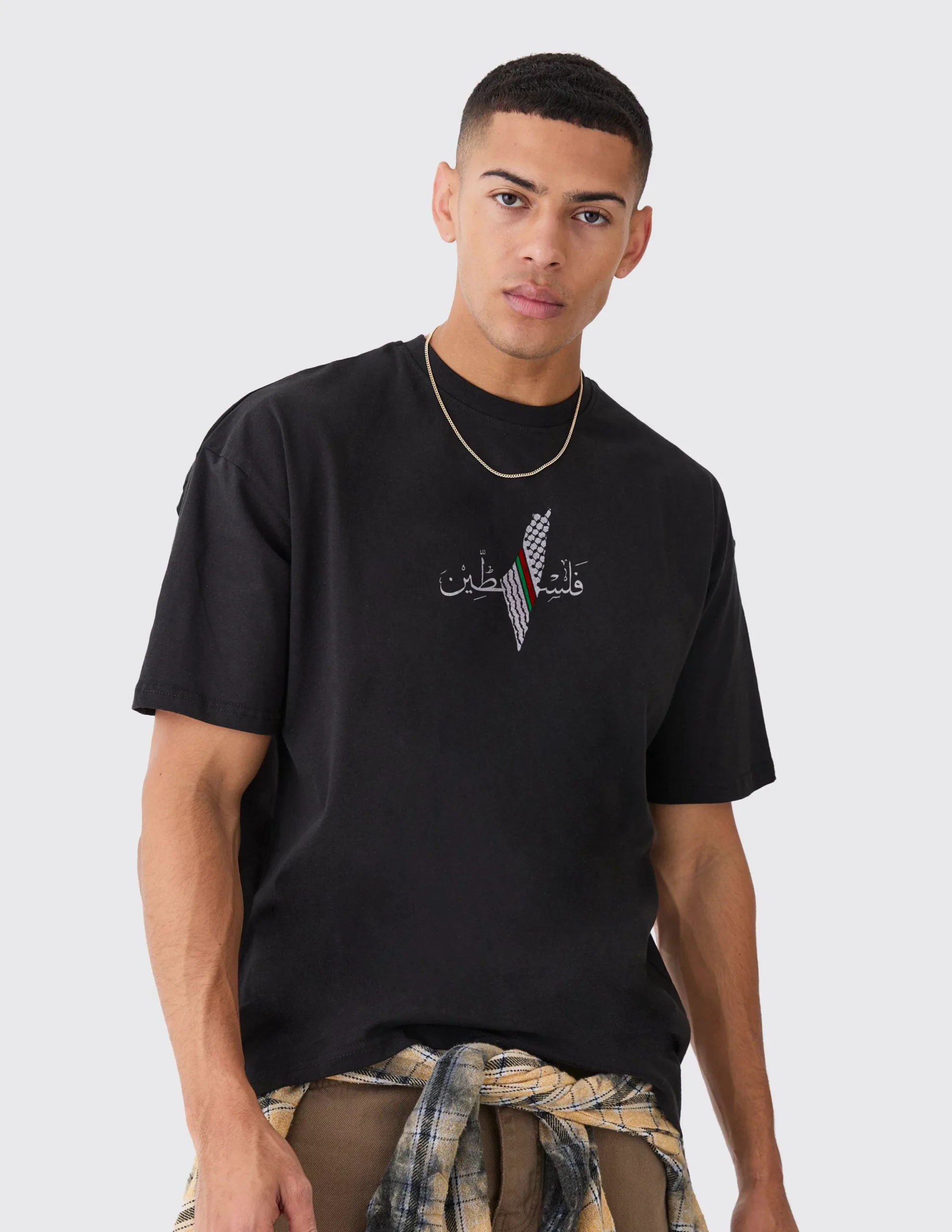 Man wearing oversized black Palestine T-shirt with Arabic فلسطين text and Palestinian flag design – only at Zaroodi India